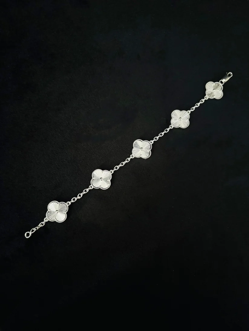 A silver chain bracelet featuring five clover-shaped links, each inlaid bracelet for her