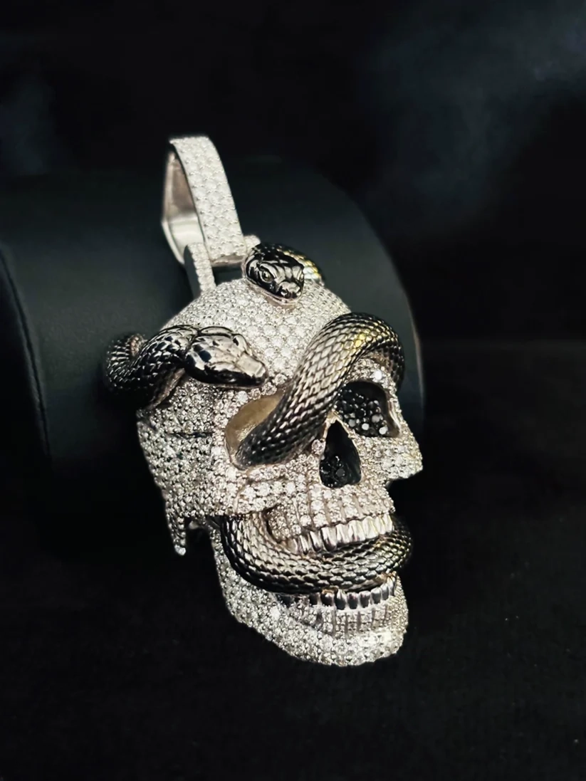 Diamond skull pendant with dark metallic snakes slithering through the eye socket and jaw.