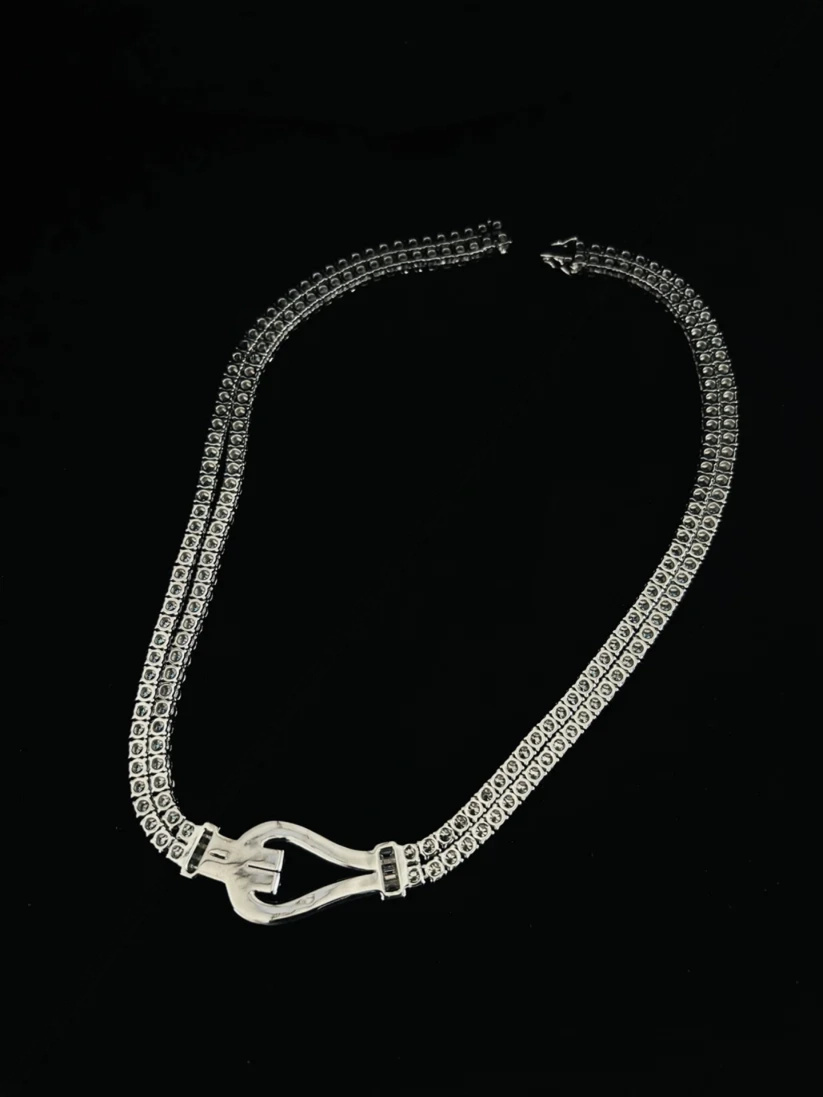 Vintage silver tennis necklace featuring a double line of crystals and an antique buckle style centerpiece