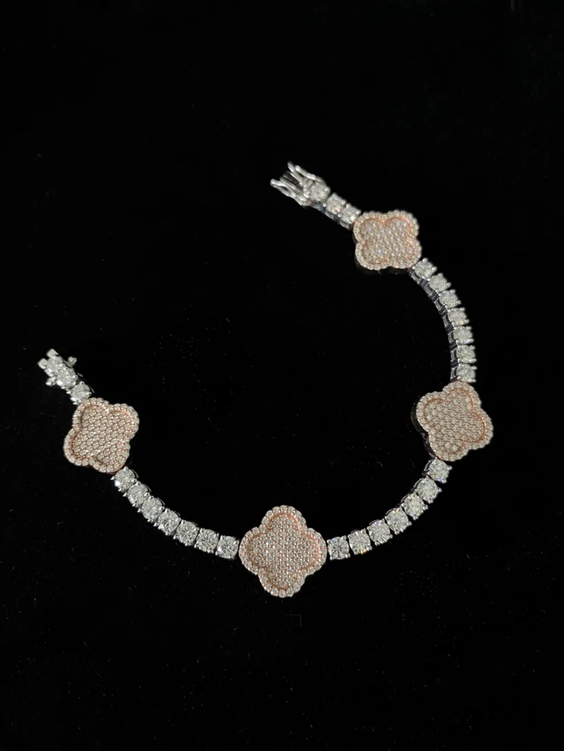 A four-piece tennis bracelet featuring pave-set clover motifs separated by rows of clear pave diamonds
