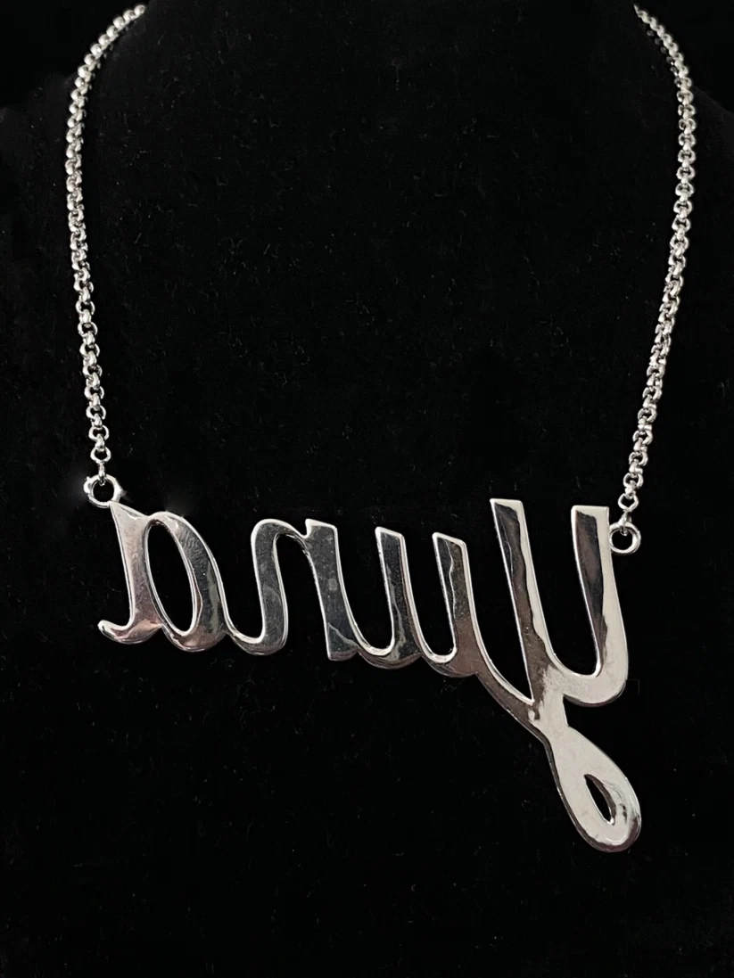 back view Silver cursive nameplate necklace featuring the name Yuna on a delicate chain