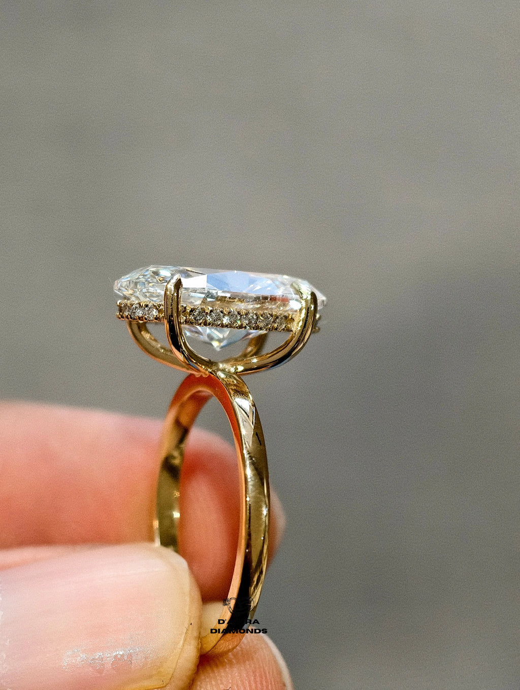 oval cut diamond engagement ring with a gold band 