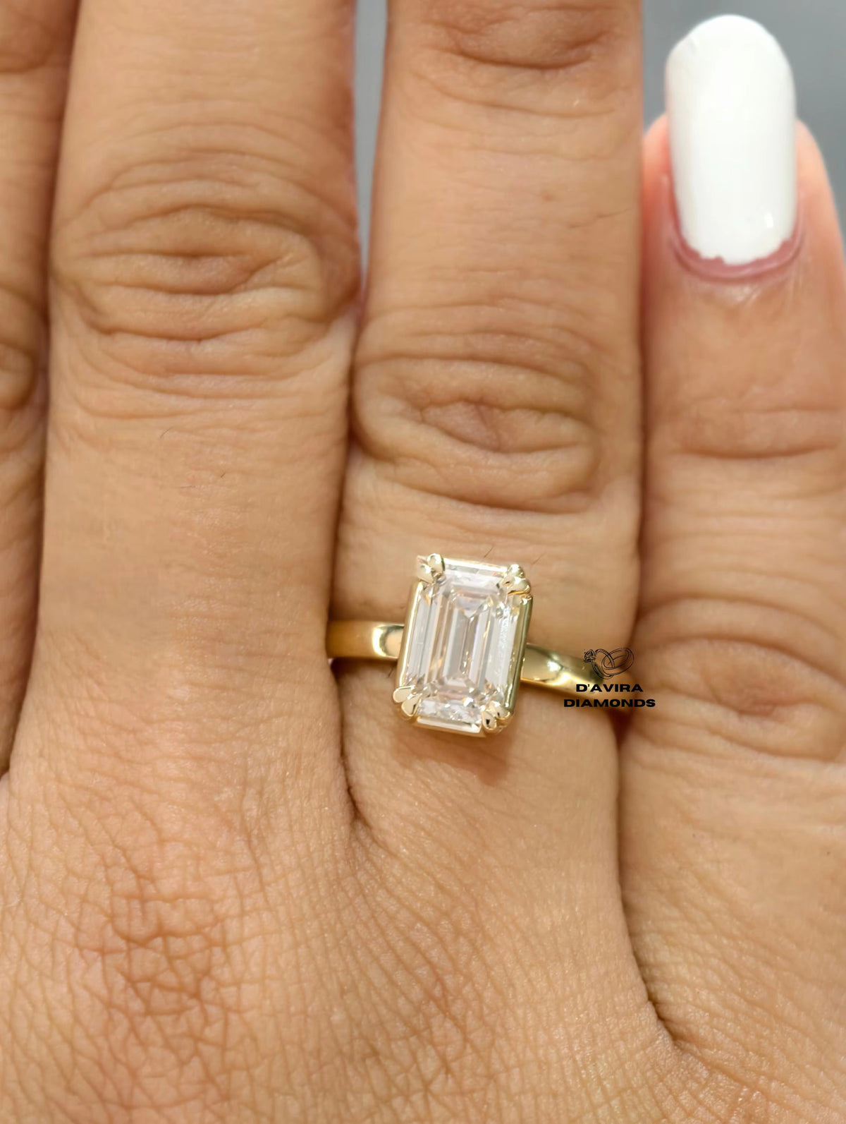 A close-up of a hand wearing a yellow gold ring