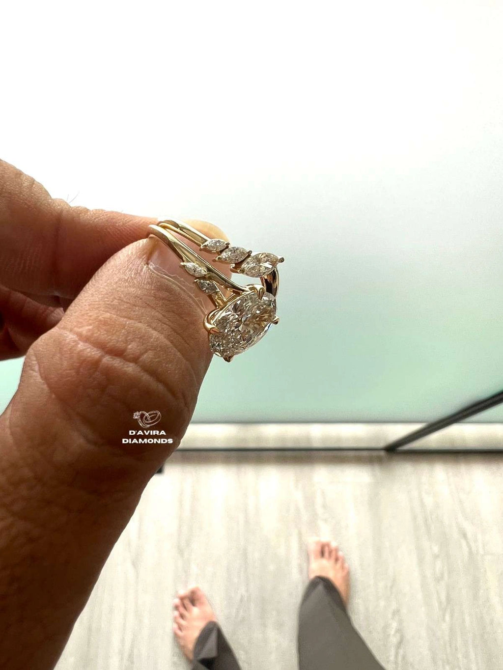 side profile of a hand holding a ring with a diamond cluster
