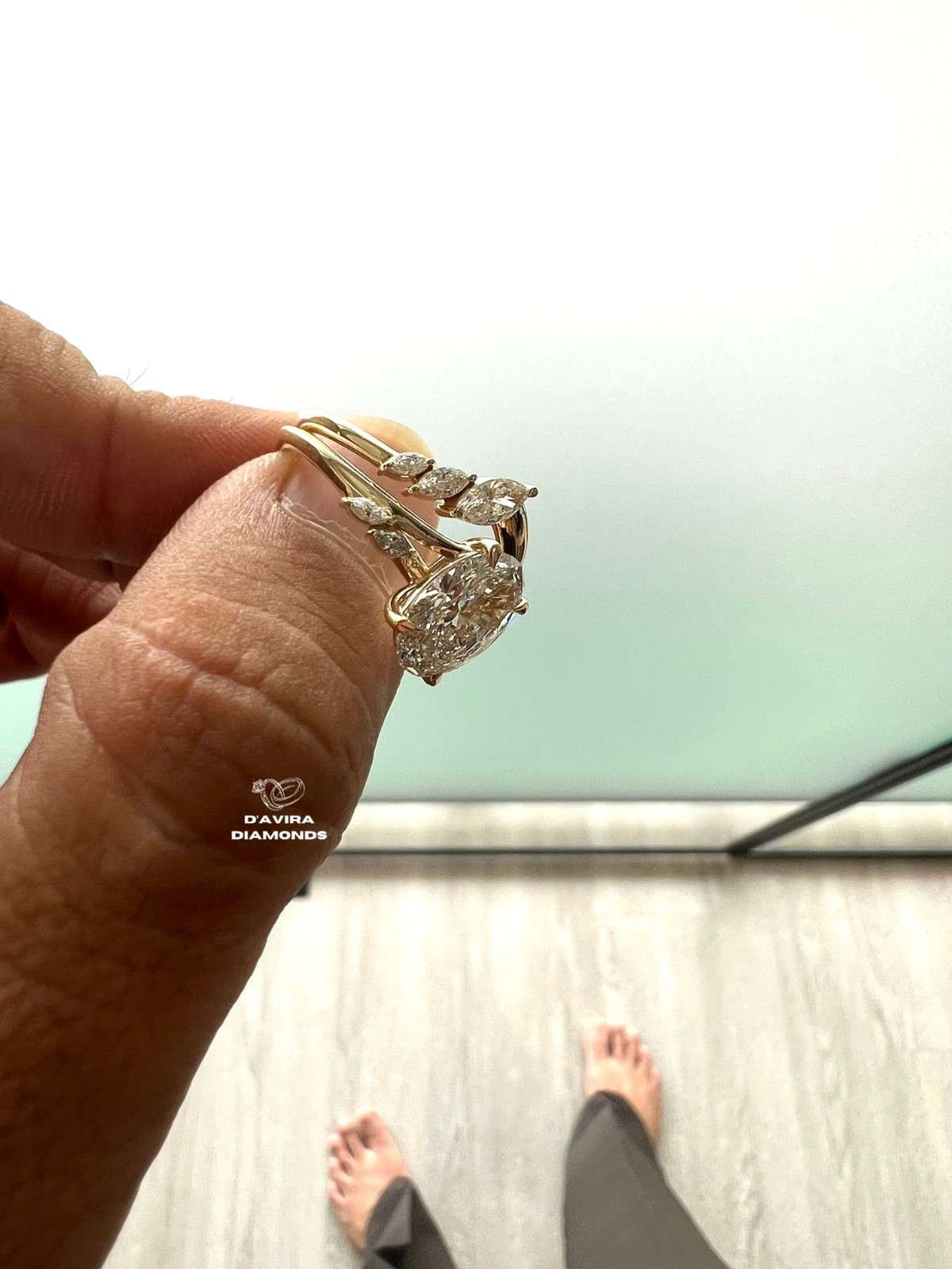 side profile of a hand holding a ring with a diamond cluster