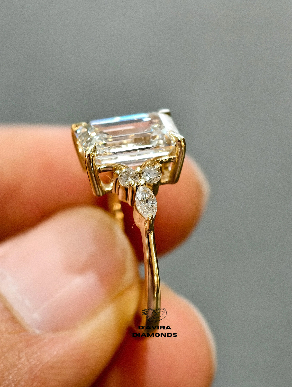 side view yellow gold setting with marquise and round cluster side stones