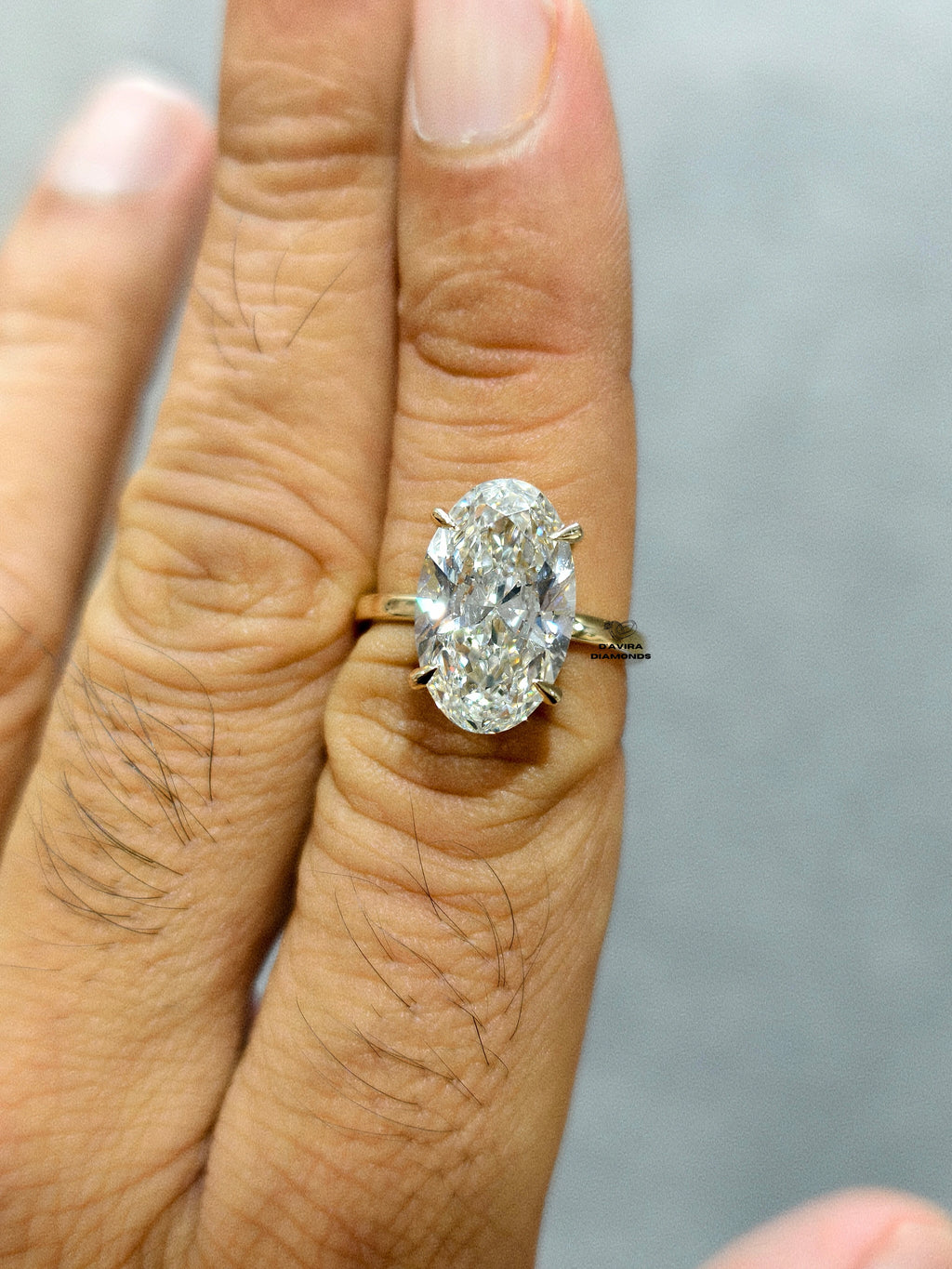 side view oval cut center stone with a halo in a yellow gold 