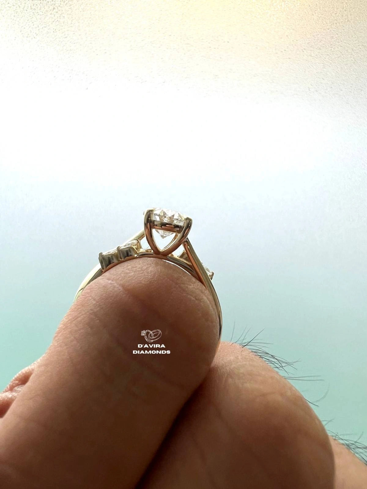 Side profile view of a oval diamond engagement ring with a bypass band 