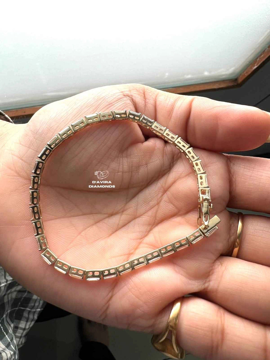 Bezel set emerald cut lab diamond line bracelet in yellow gold setting 