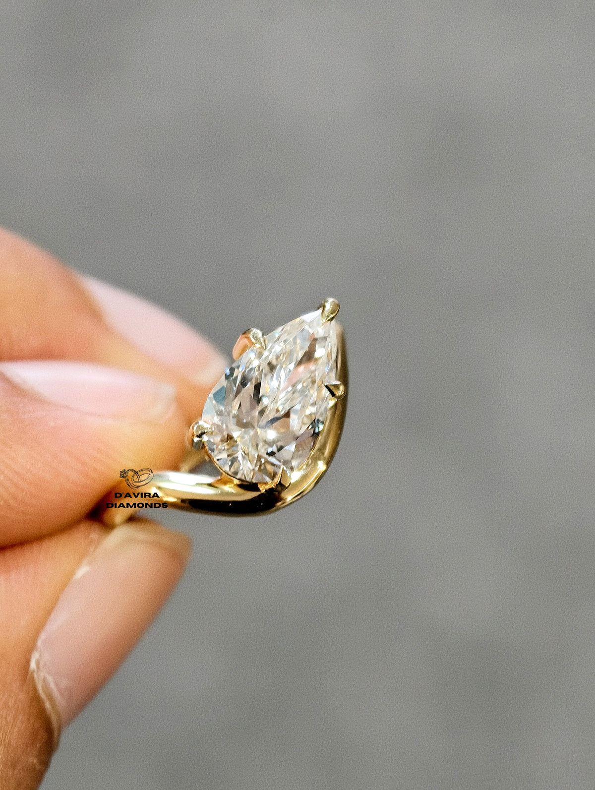 hand holding of solitaire pear cut diamond ring