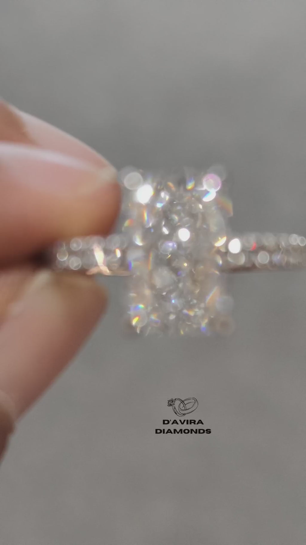 video of front view hand holding a diamond ring with a radiant cut center stone and pave band