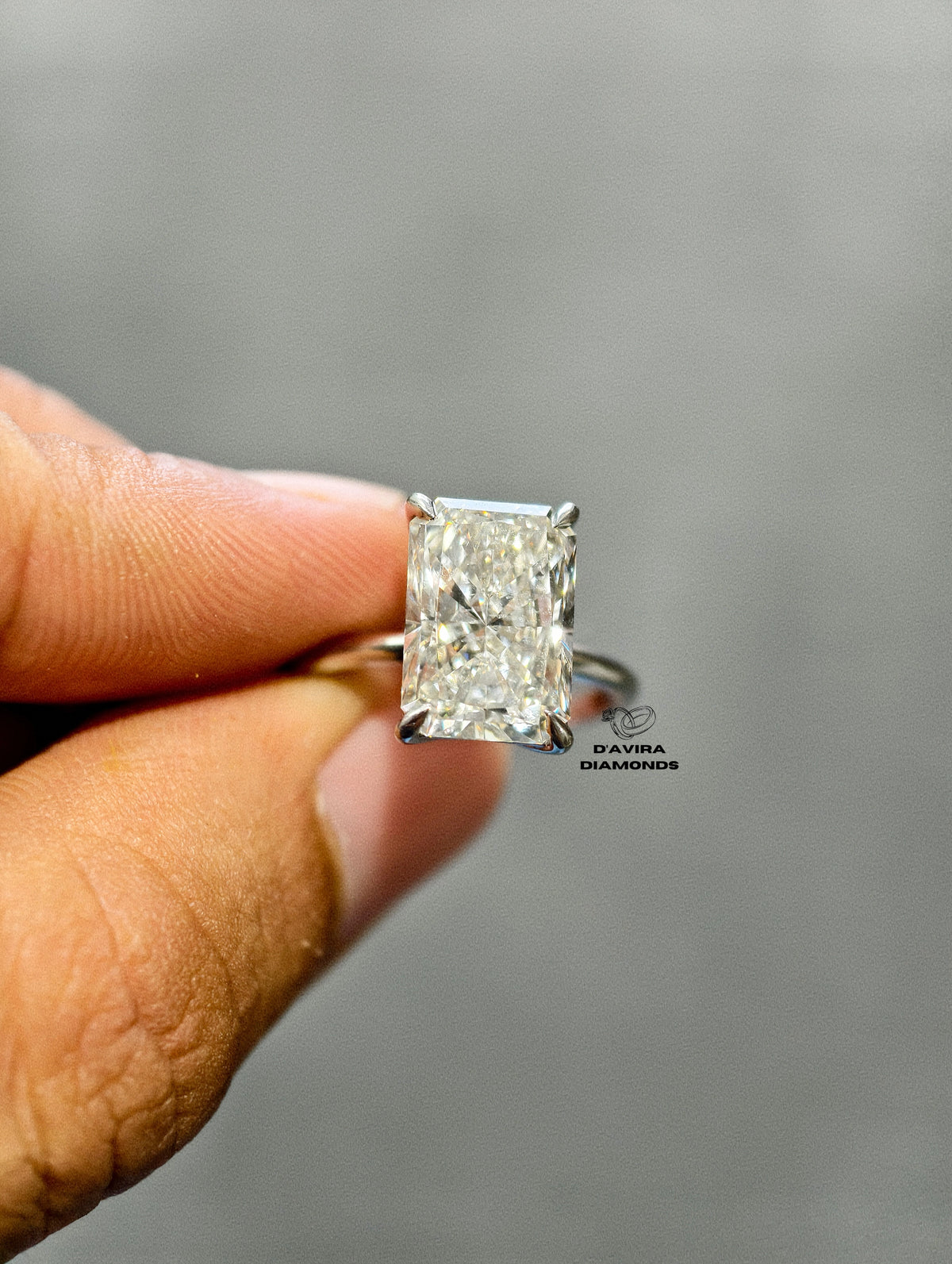 Radiant-cut diamond solitaire ring with a center stone on a slim white gold band
