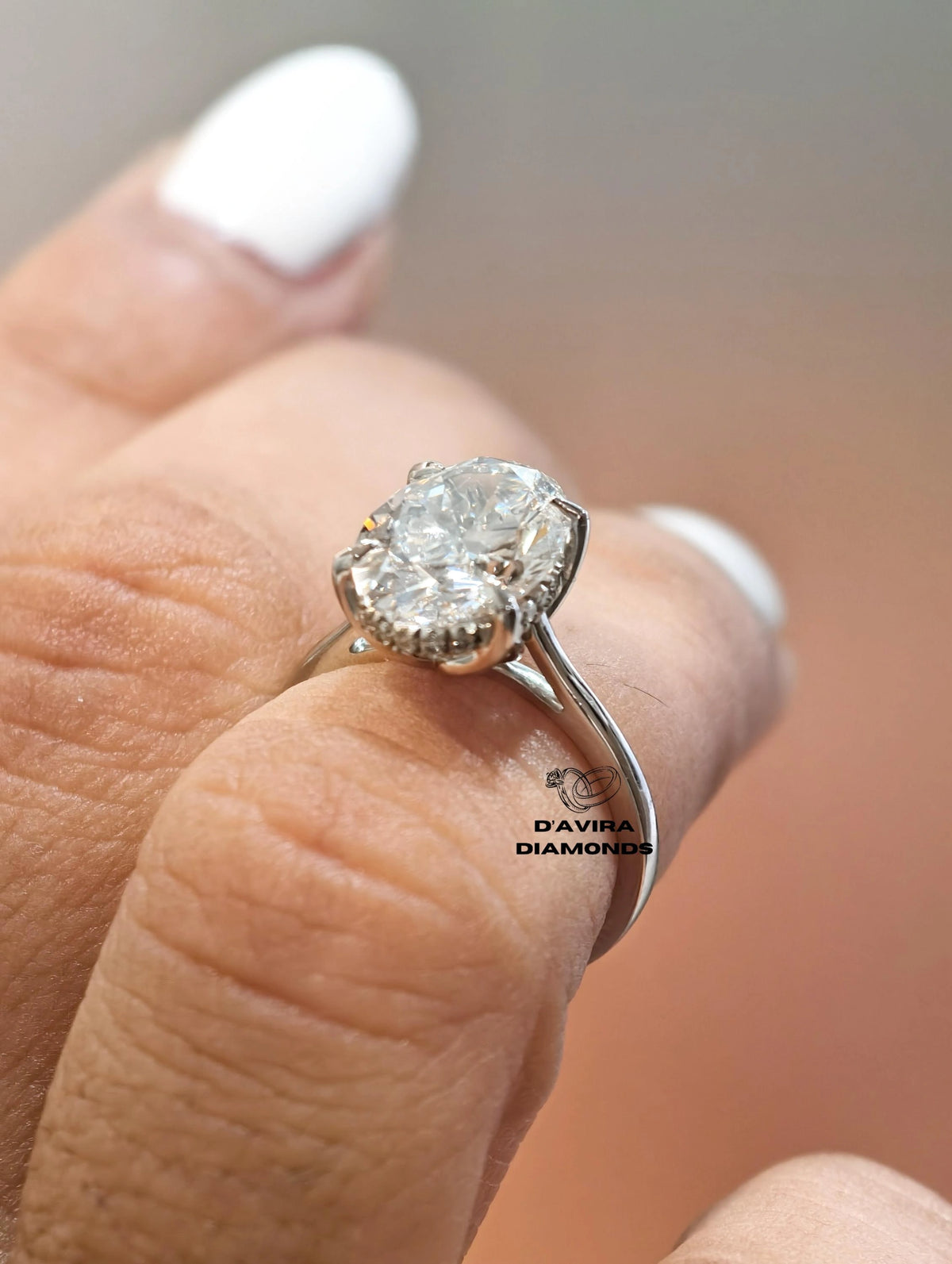 Oval cut diamond ring with hidden halo on split shank band worn on finger