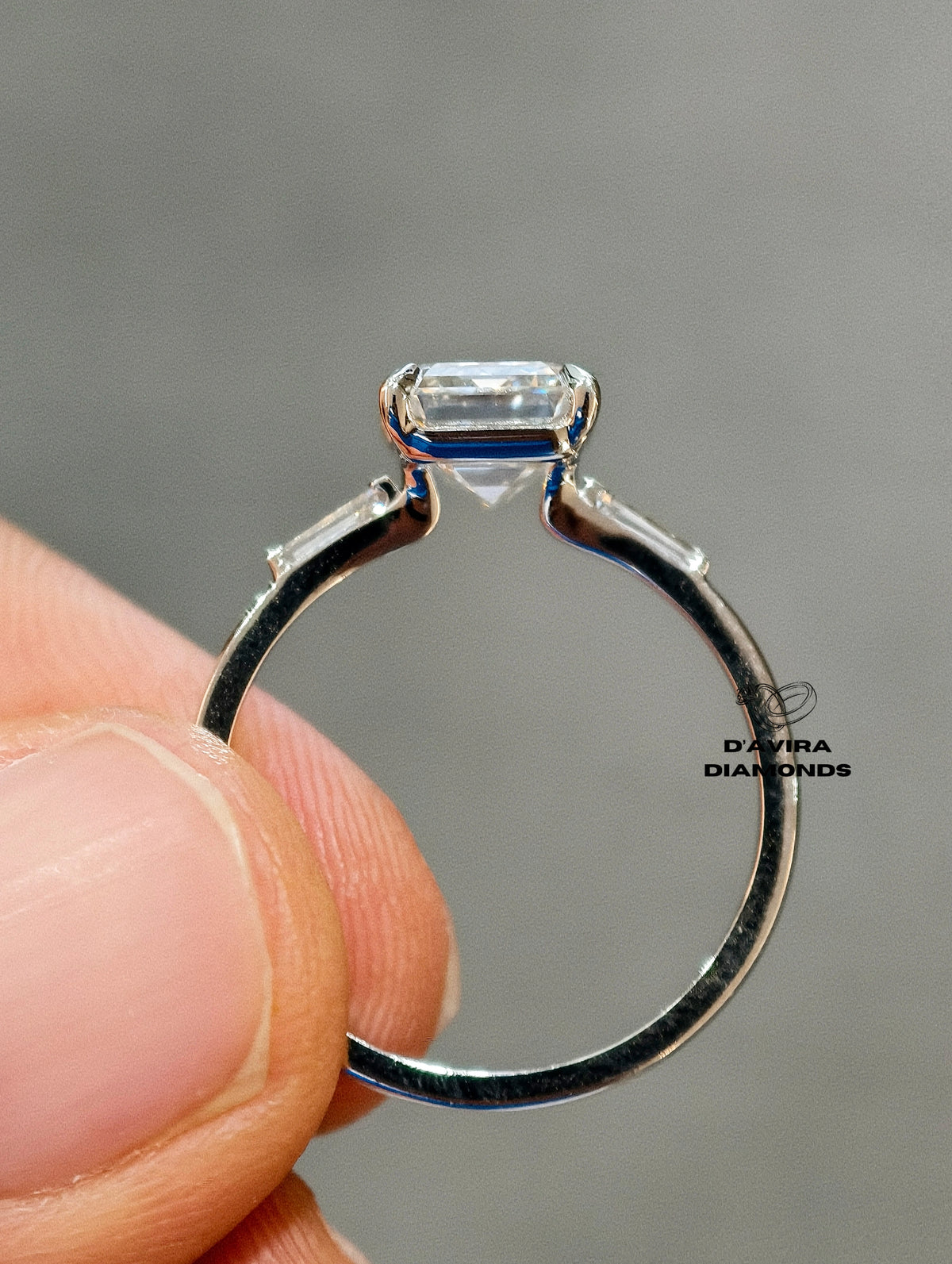 back view of a hand holding an emerald cut lab diamond ring