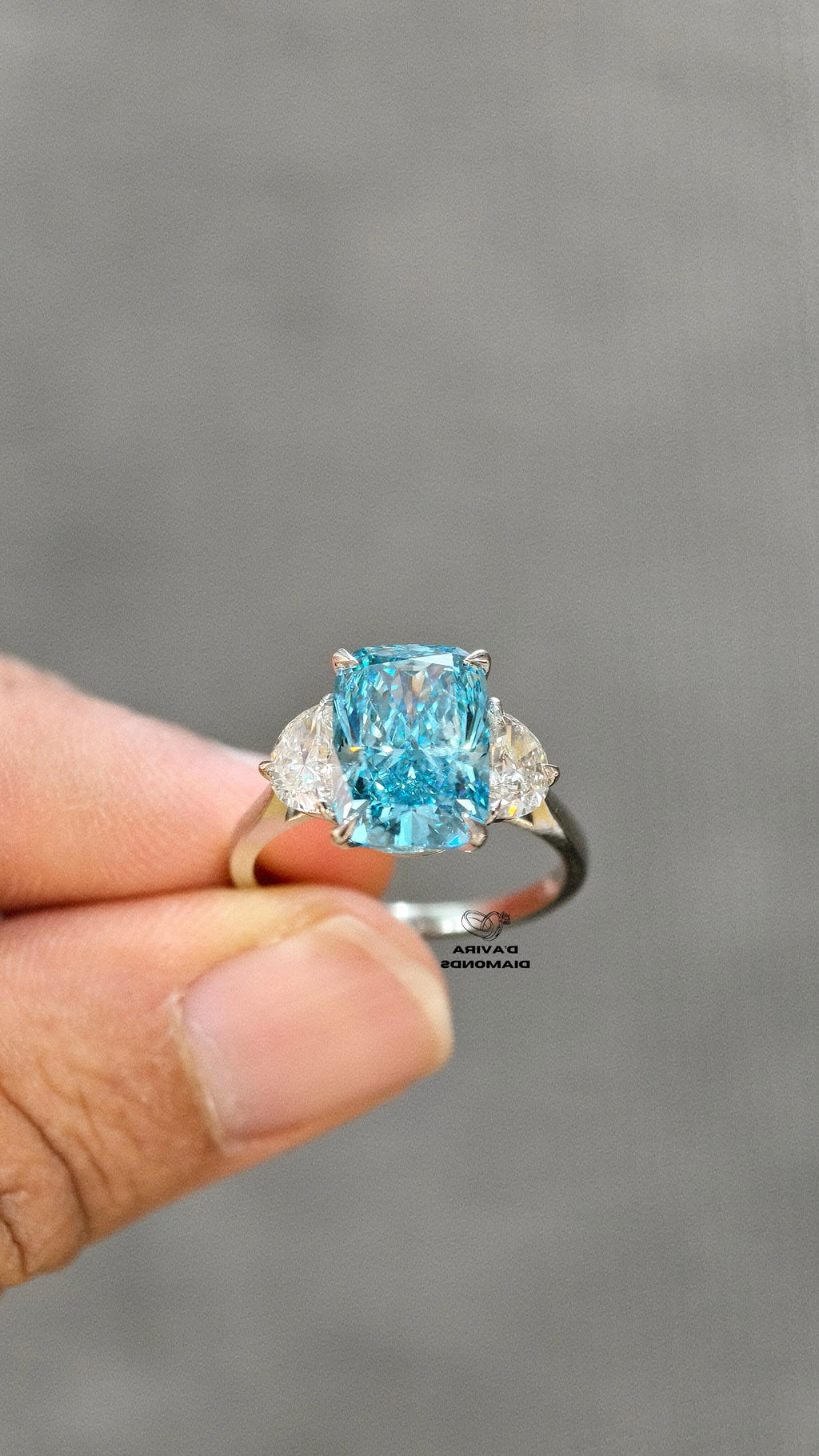 hand holding of 14K white gold blue radiant cut diamond ring 