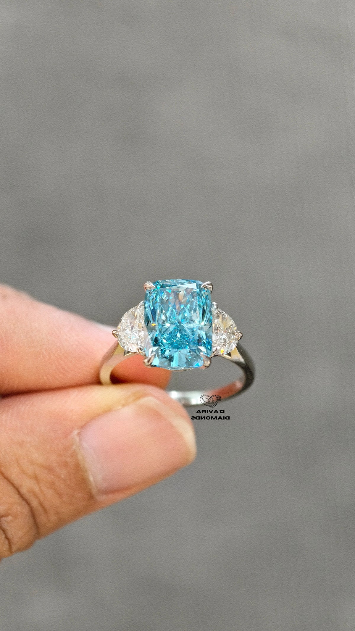 hand holding of 14K white gold blue radiant cut diamond ring 